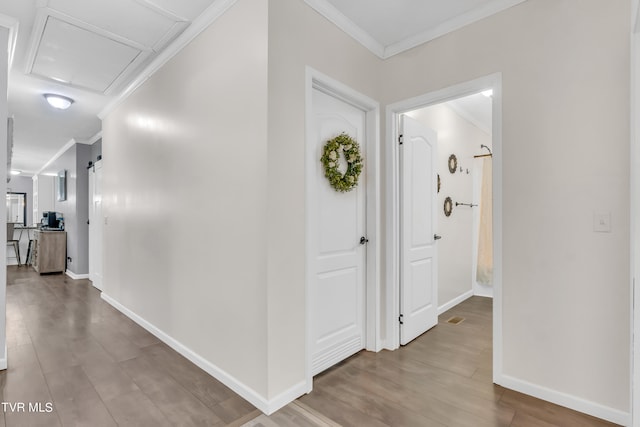 corridor featuring ornamental molding and hardwood / wood-style floors