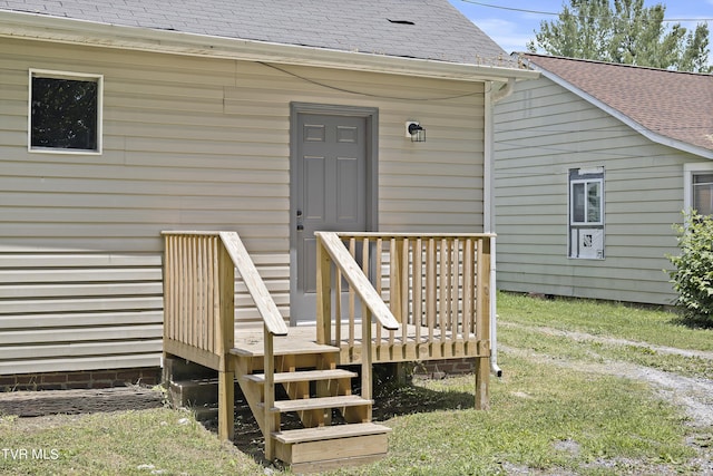 entrance to property with a wooden deck and a yard