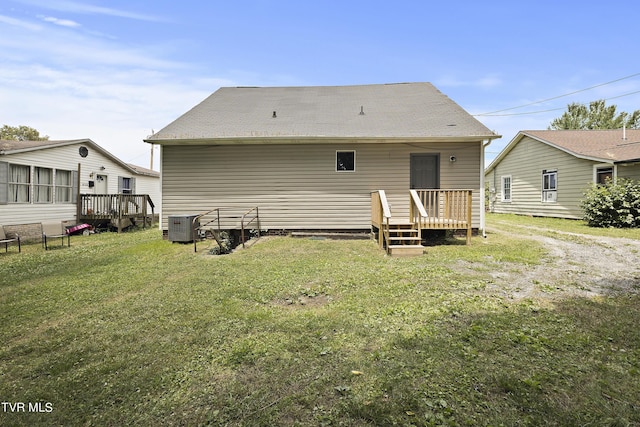 rear view of house with central AC unit, a lawn, and a deck