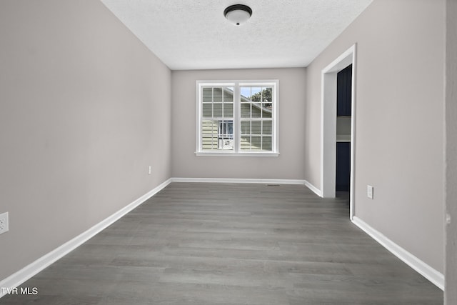 unfurnished room with hardwood / wood-style flooring and a textured ceiling