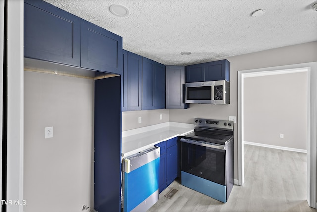 kitchen featuring appliances with stainless steel finishes, blue cabinets, light hardwood / wood-style floors, and a textured ceiling