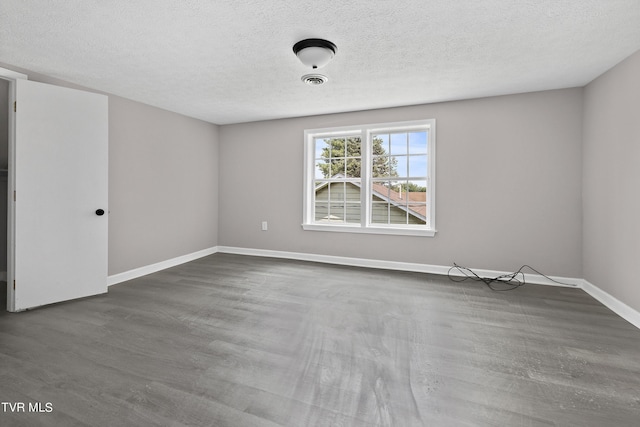 spare room with hardwood / wood-style floors and a textured ceiling