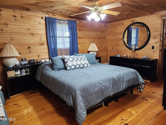 bedroom with light hardwood / wood-style floors, wood ceiling, and wood walls