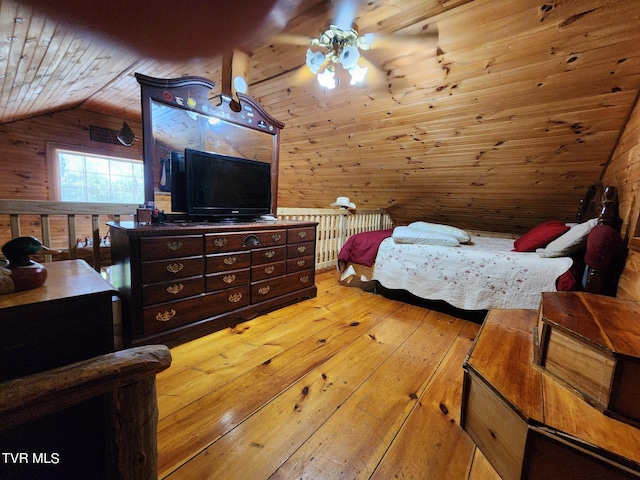 bedroom featuring wooden walls, light hardwood / wood-style floors, vaulted ceiling, and wooden ceiling