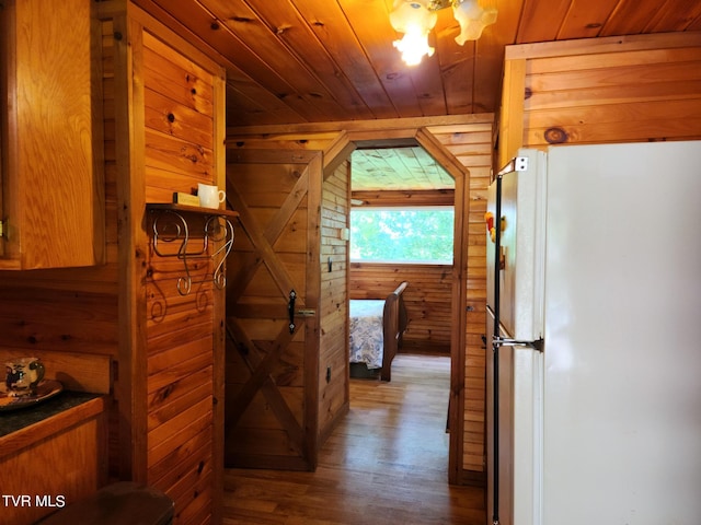 corridor featuring wood ceiling, hardwood / wood-style flooring, and wooden walls