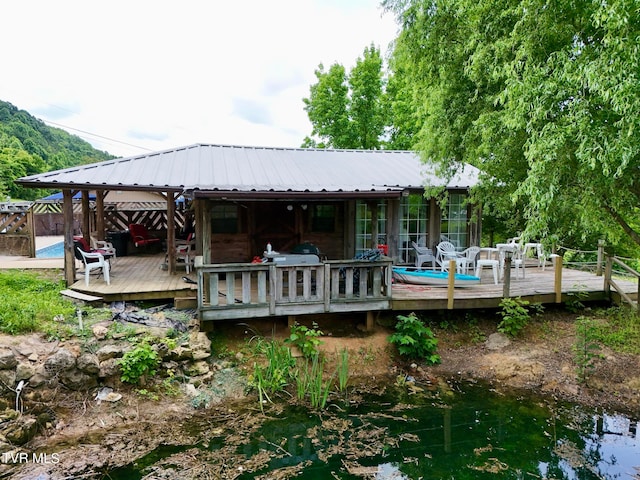 rear view of house featuring a wooden deck and a gazebo