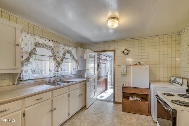 kitchen featuring white electric range oven, light tile flooring, tile walls, sink, and white cabinetry