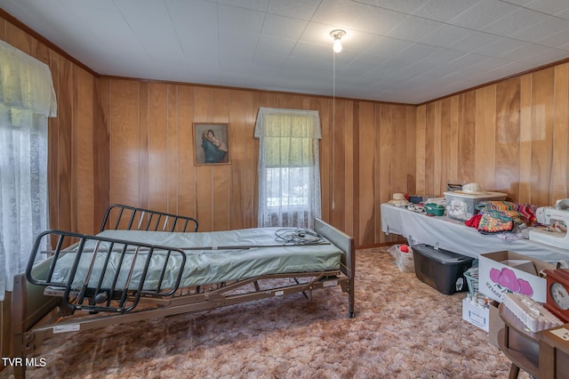 bedroom with wood walls and carpet flooring