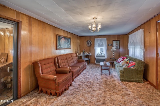 carpeted living room with wood walls and a chandelier