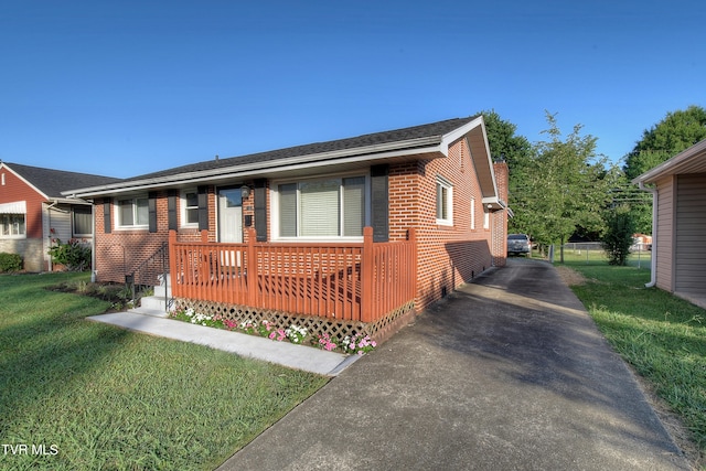 view of front of property with a deck and a front lawn