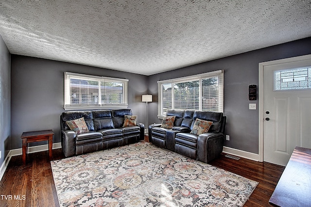 living room featuring dark hardwood / wood-style flooring and a textured ceiling