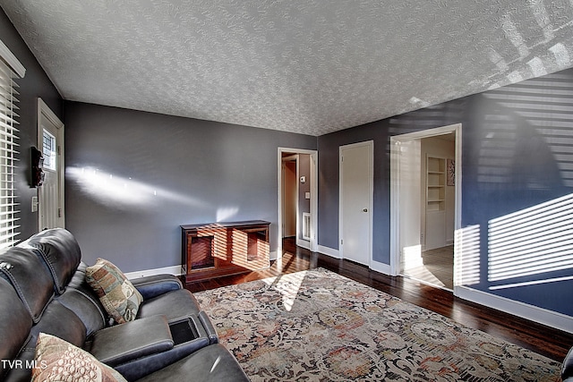 living room with dark hardwood / wood-style flooring and a textured ceiling