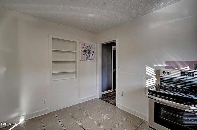 kitchen featuring electric range, a textured ceiling, and built in shelves