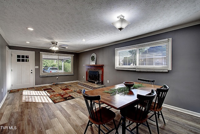 unfurnished dining area featuring crown molding, a brick fireplace, dark hardwood / wood-style flooring, and a textured ceiling