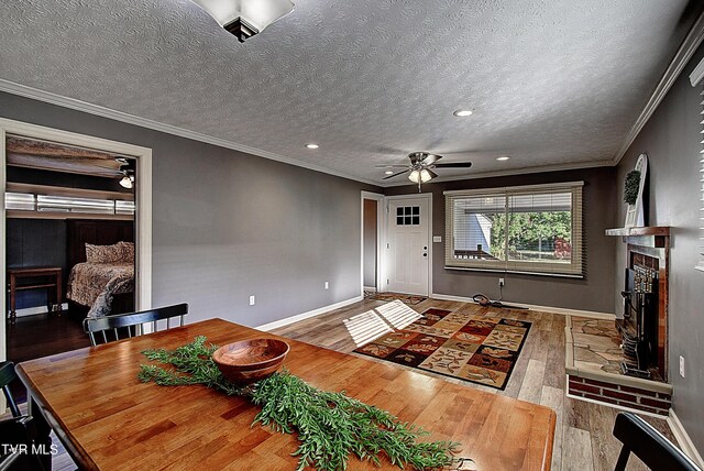 living room with crown molding, a textured ceiling, ceiling fan, and wood-type flooring