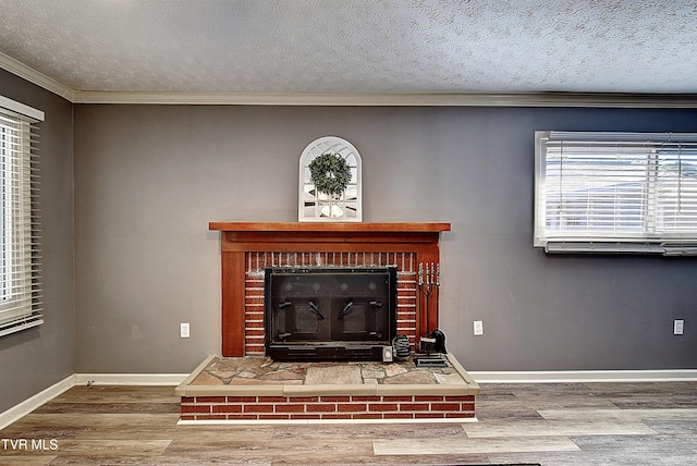 details with a textured ceiling, ornamental molding, a brick fireplace, and hardwood / wood-style floors