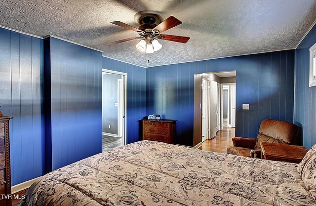 bedroom featuring a textured ceiling, ceiling fan, and wood-type flooring