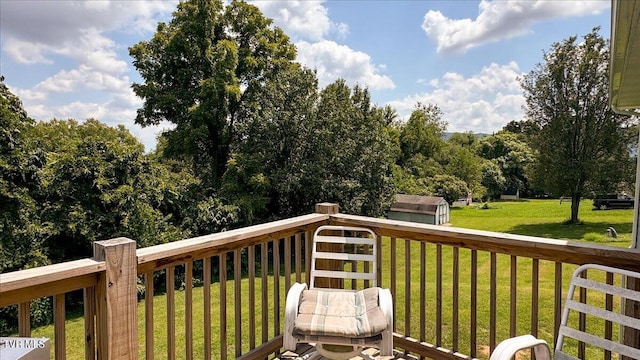 deck with a storage shed and a lawn