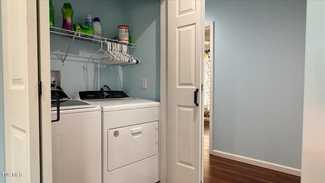 clothes washing area with washer and dryer and dark wood-type flooring