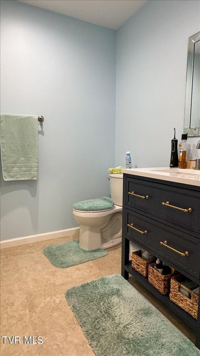 bathroom with vanity, tile patterned flooring, and toilet