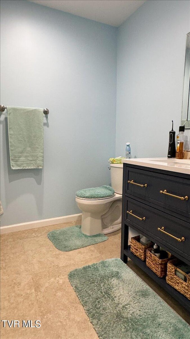 bathroom with toilet, tile patterned floors, and vanity