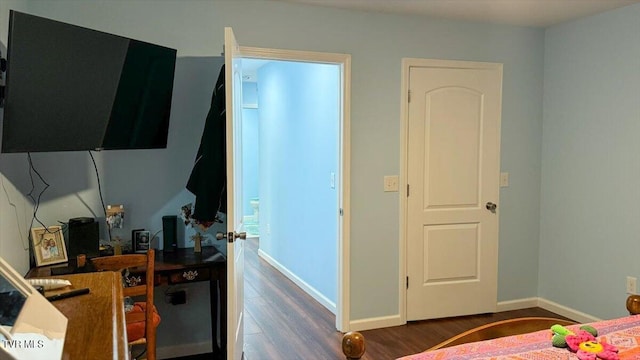 bedroom with dark hardwood / wood-style flooring