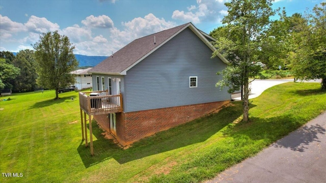 view of home's exterior with a yard and a deck