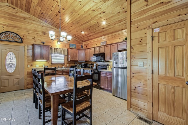 kitchen with light tile patterned floors, high vaulted ceiling, hanging light fixtures, and black appliances