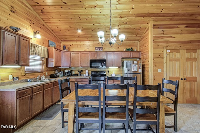 kitchen featuring stainless steel fridge, light tile patterned floors, range, hanging light fixtures, and lofted ceiling