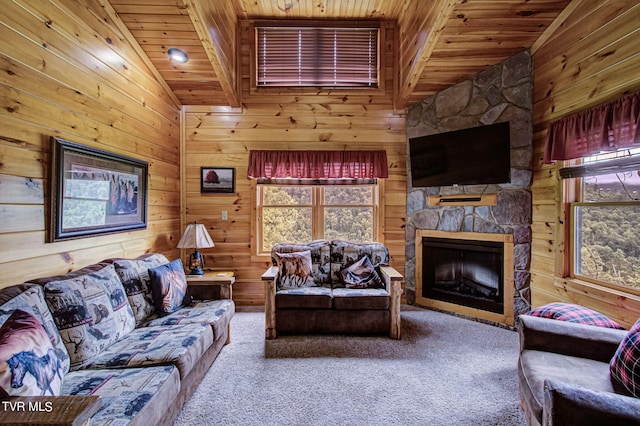 living room with a stone fireplace, carpet floors, wood ceiling, and vaulted ceiling