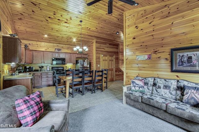 living room with a high ceiling, sink, wooden walls, light tile patterned floors, and wood ceiling