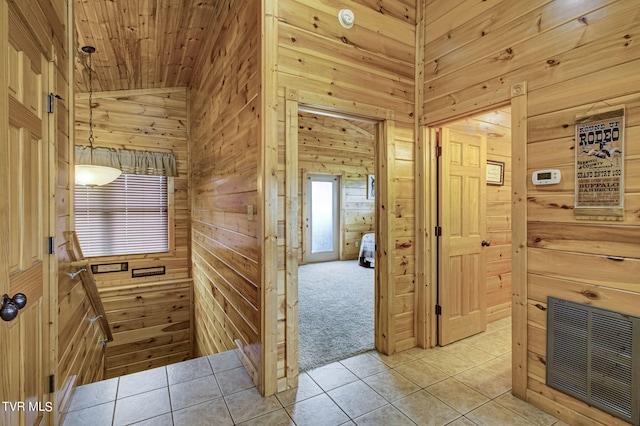 interior space with light carpet, vaulted ceiling, and wood walls