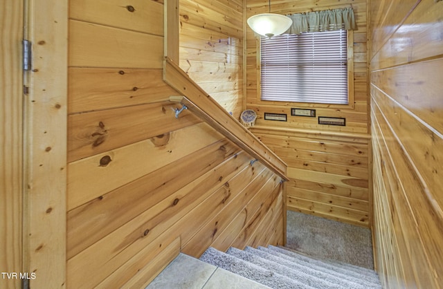 stairway featuring wood walls