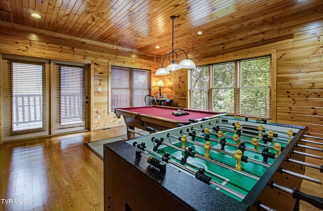 rec room featuring wooden walls, light hardwood / wood-style flooring, a healthy amount of sunlight, and pool table