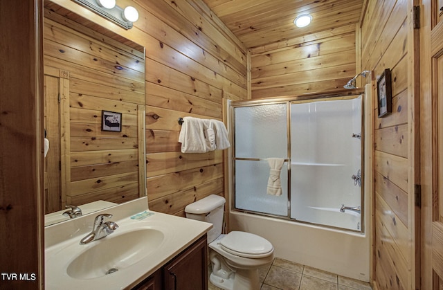 full bathroom with vanity, bath / shower combo with glass door, wooden ceiling, and wood walls