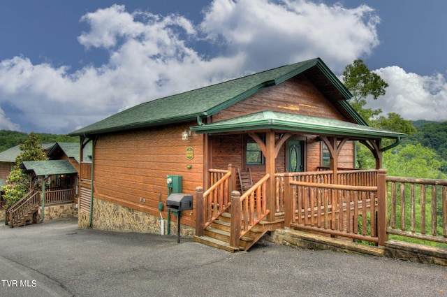 log-style house featuring covered porch