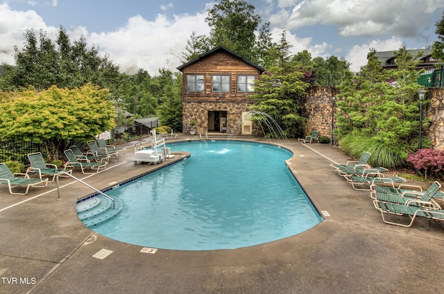 view of swimming pool with a patio and an outdoor fireplace