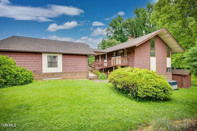 back of house with a deck and a lawn