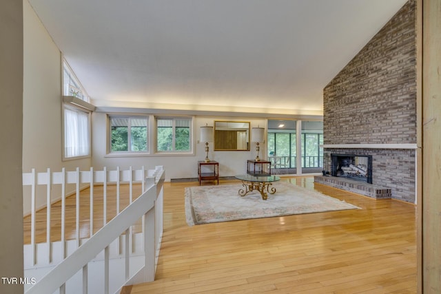 unfurnished living room featuring hardwood / wood-style floors, a healthy amount of sunlight, and a brick fireplace