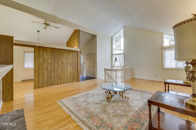 sitting room with hardwood / wood-style floors, ceiling fan, and high vaulted ceiling