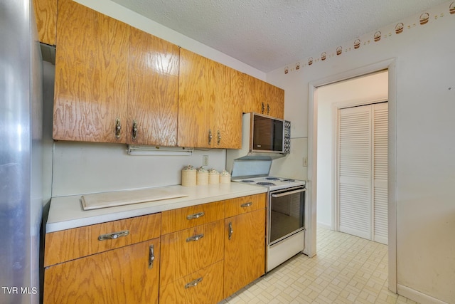 kitchen featuring electric stove and a textured ceiling