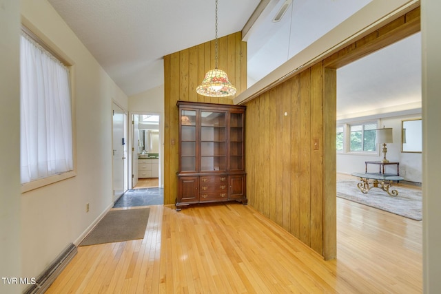 interior space featuring wooden walls, vaulted ceiling, and hardwood / wood-style flooring