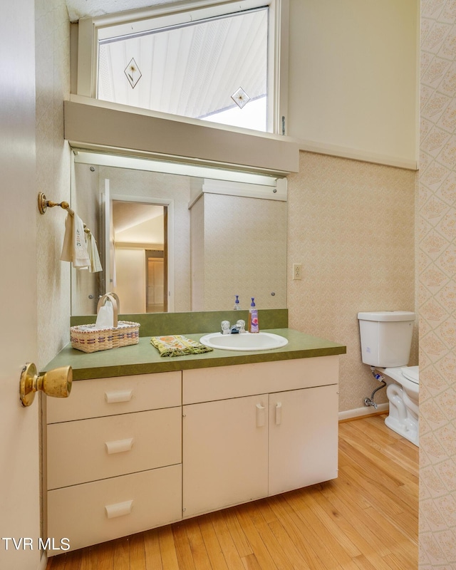 bathroom with hardwood / wood-style floors, vanity, and toilet