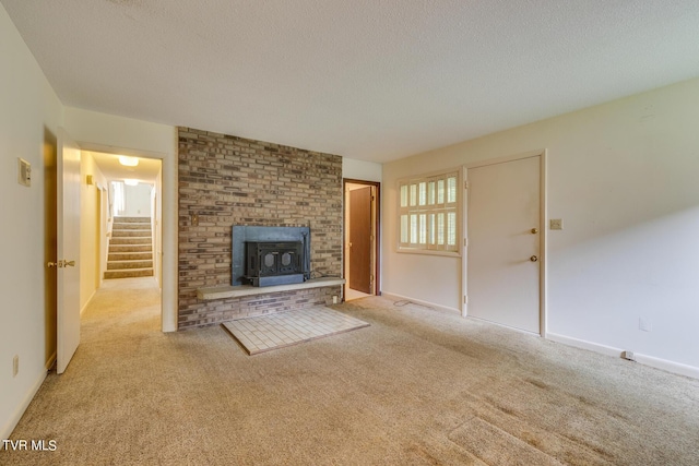 unfurnished living room featuring a textured ceiling, a wood stove, and light carpet