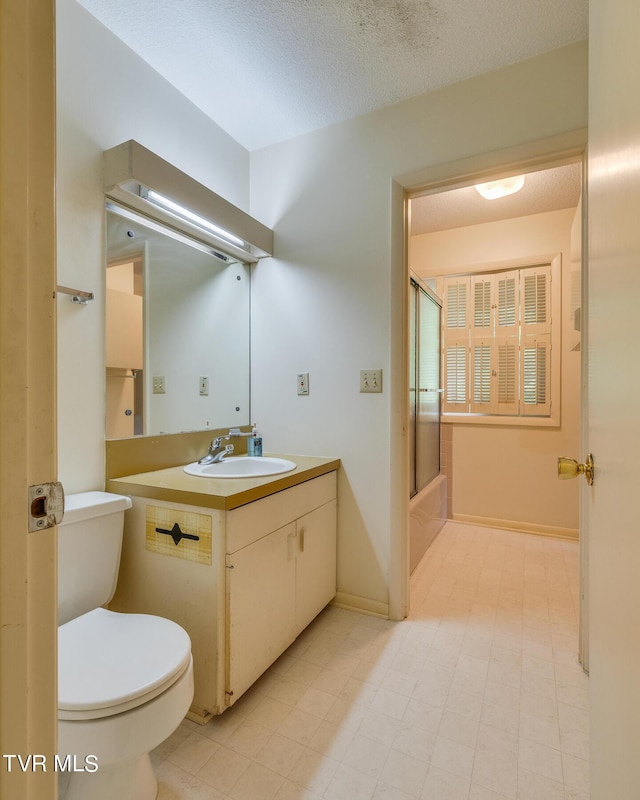 full bathroom with shower / bath combination with glass door, vanity, a textured ceiling, and toilet