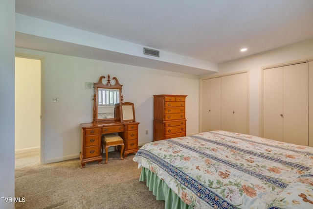 bedroom with carpet flooring and multiple closets