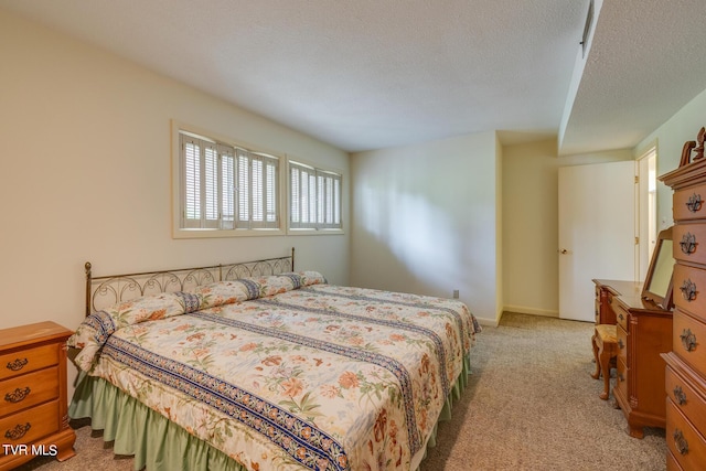 bedroom with light colored carpet and a textured ceiling