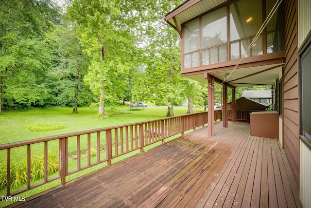 deck with a sunroom and a lawn