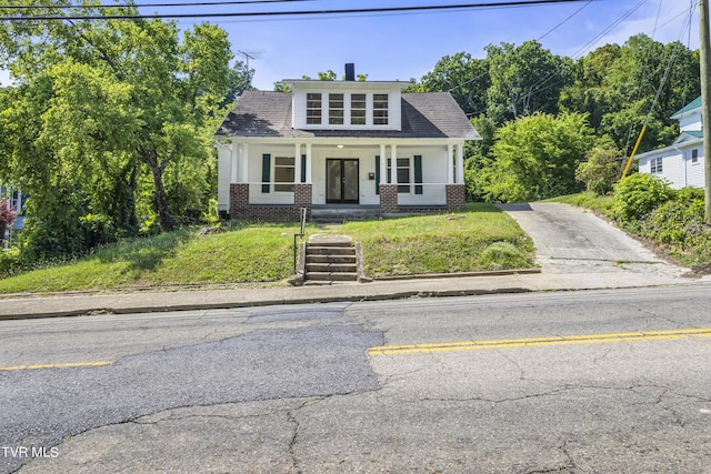 view of front of house with a porch and a front lawn