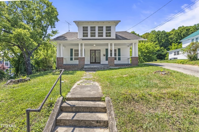 view of front of home with a porch and a front yard